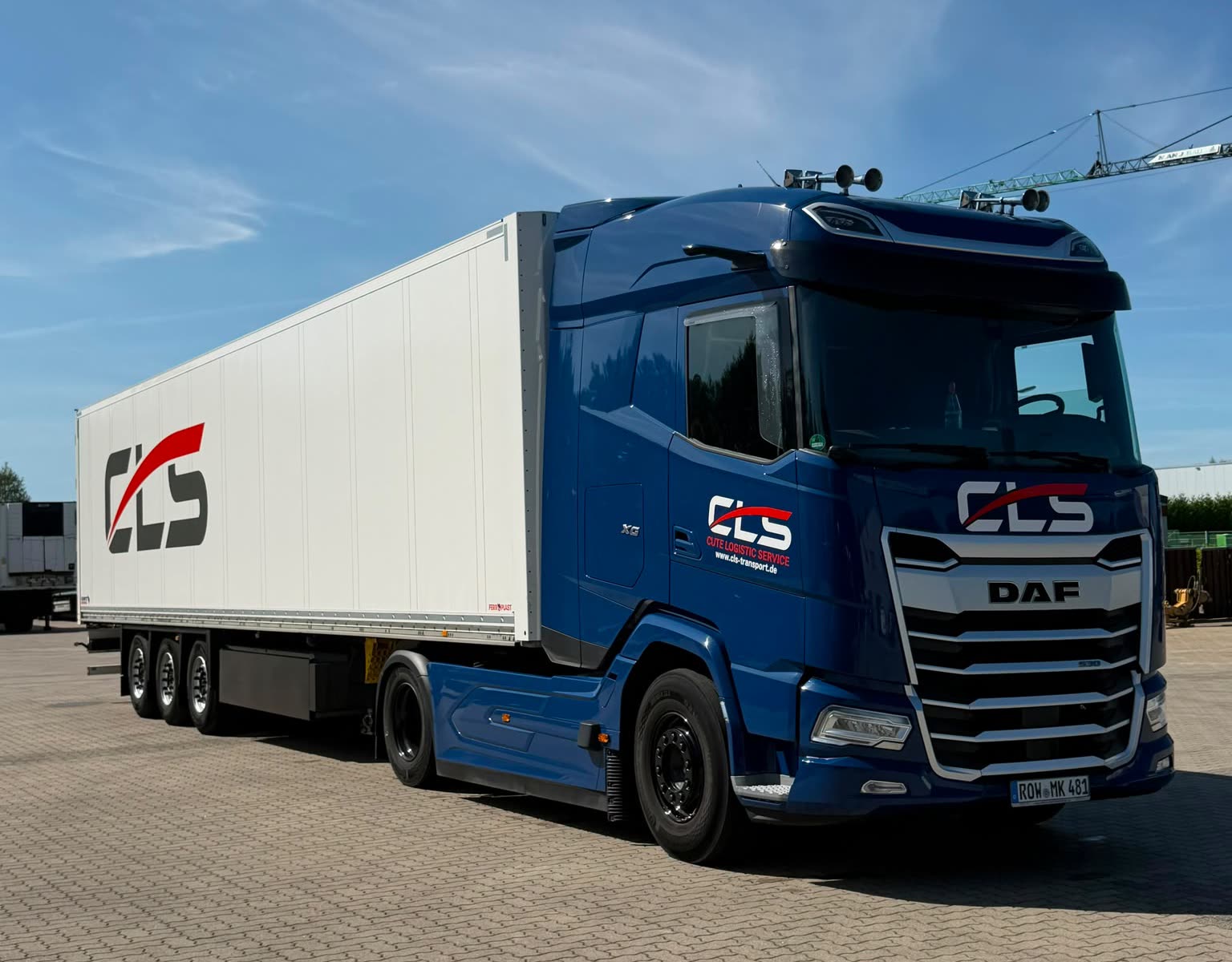 Blauer DAF-Sattelzug der CLS mit weißem CLS-Kofferauflieger auf dem Betriebshof